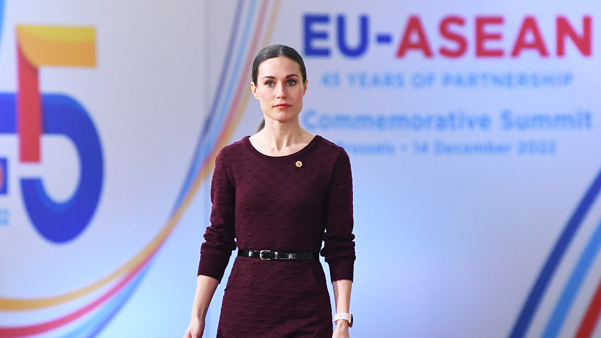 Pääministeri Marin kävelee Europa-rakennuksessa, takan EU-ASEAN huippukokouksen logot