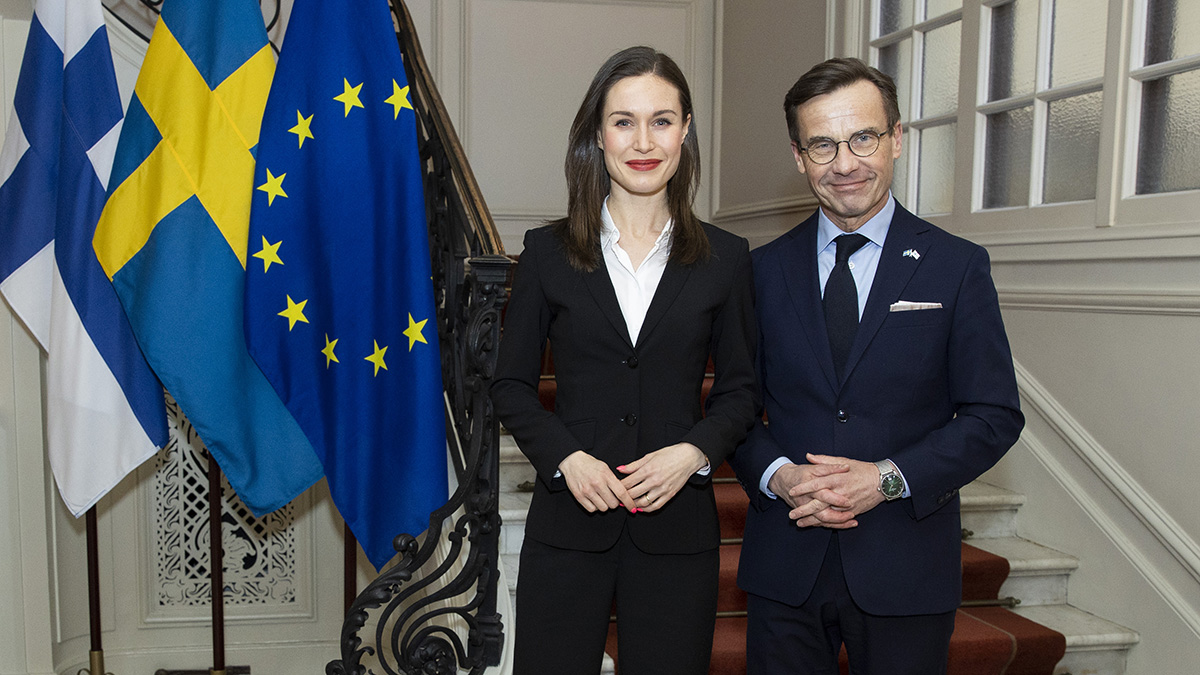 Pääministerit Marin ja Kristersson seisovat vierekkäin, sivulla Suomen, Ruotsin ja EU:n liput