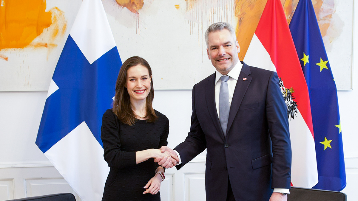 Pääministeri Marin ja liittokansleri Nehammer Suomen, Itävallan ja EU:n lippujen edessä.