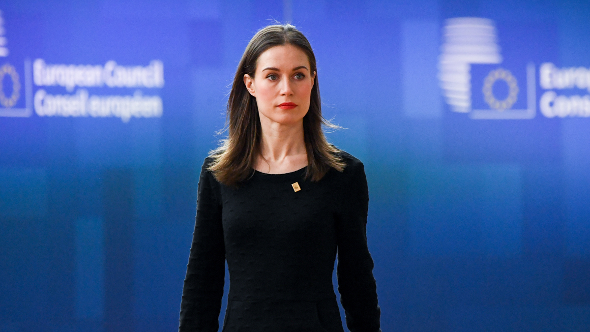 Statsminister Marin promenerar i Europa byggnaden, blå vägg på bakom